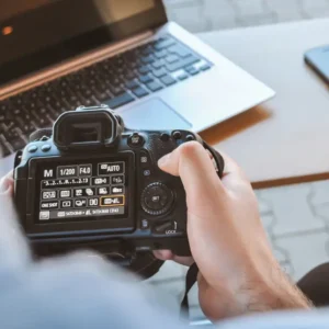 Adjusting DSLR camera settings on a desk setup—ideal for learners of the Ultimate Photography Bundle Training Basic and Advance course.