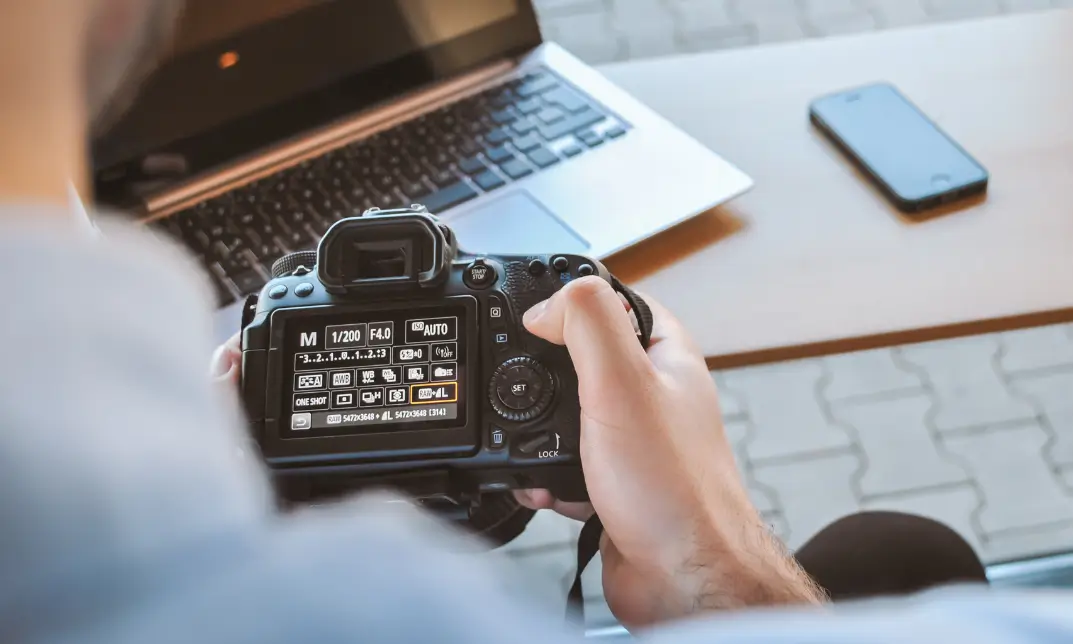 Adjusting DSLR camera settings on a desk setup—ideal for learners of the Ultimate Photography Bundle Training Basic and Advance course.