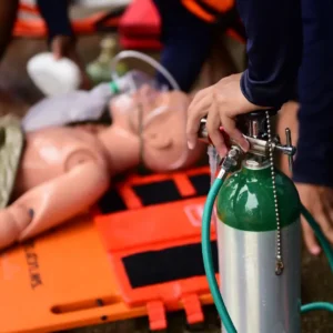 Mannequin on stretcher with oxygen mask and tank used in a hands-on session for the Oxygen First Aid Training – Online Course.